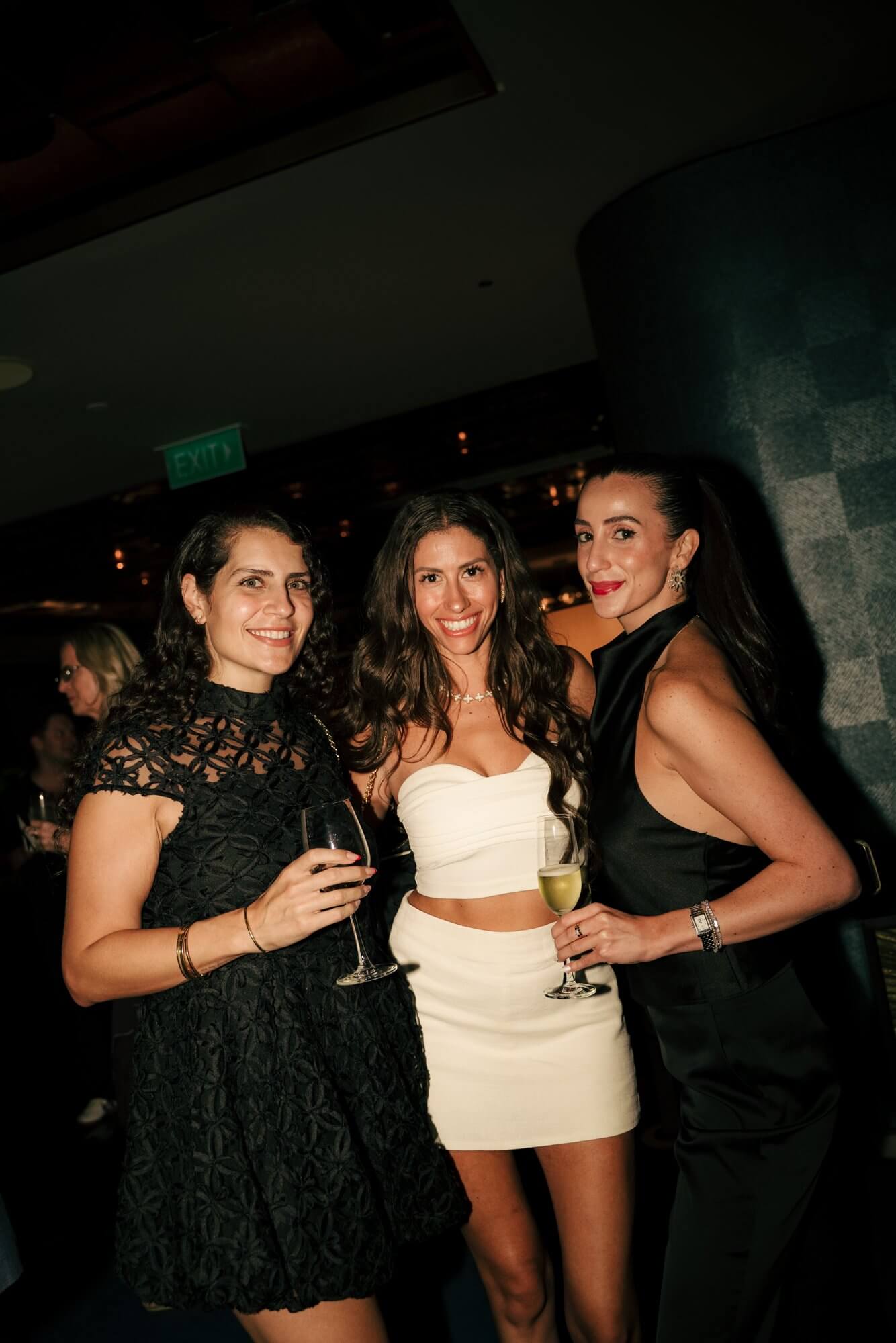 Three guests holding drinks at Mo Bar
